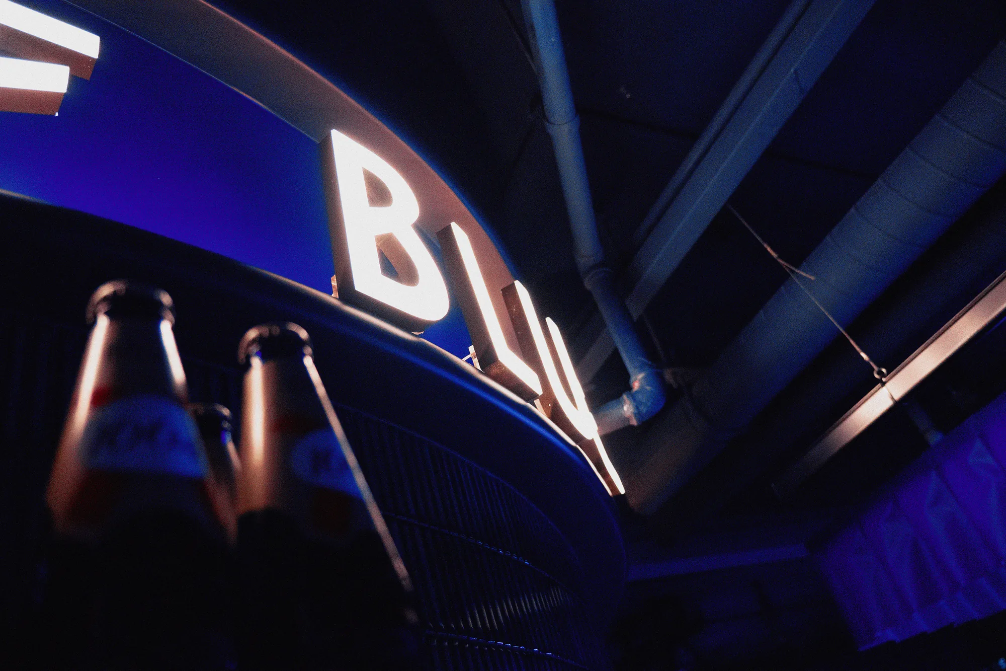 Lit BRUT letters curving along the top of the bar