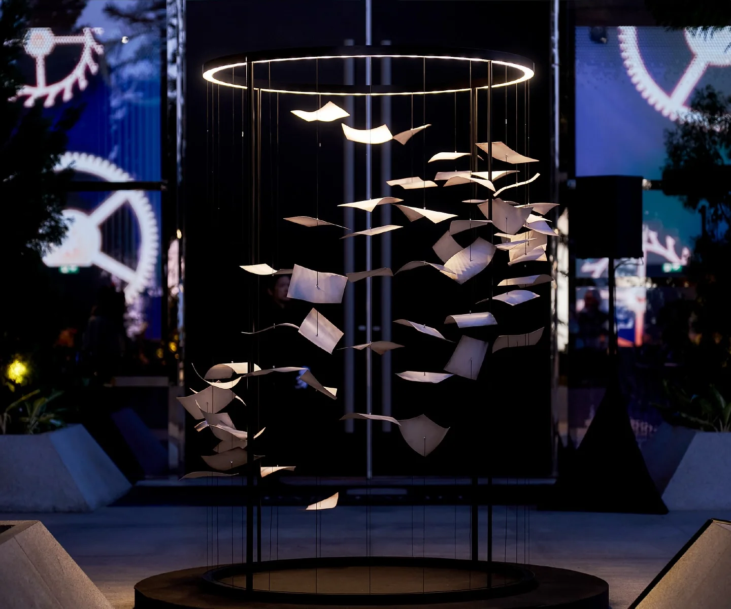 A suspended installation of floating pages under a ring of light