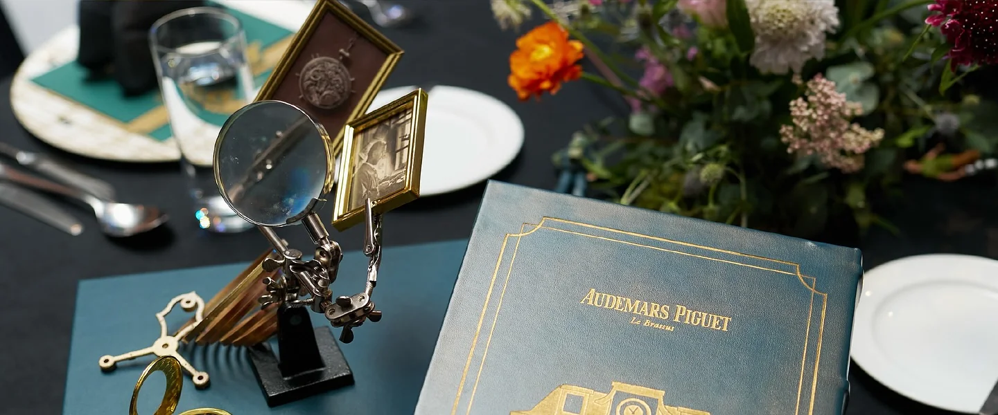 A table setting with a magnifier, menu and notebook