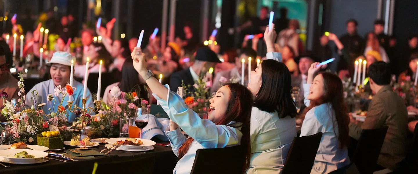 Guests at dinner raising their hands