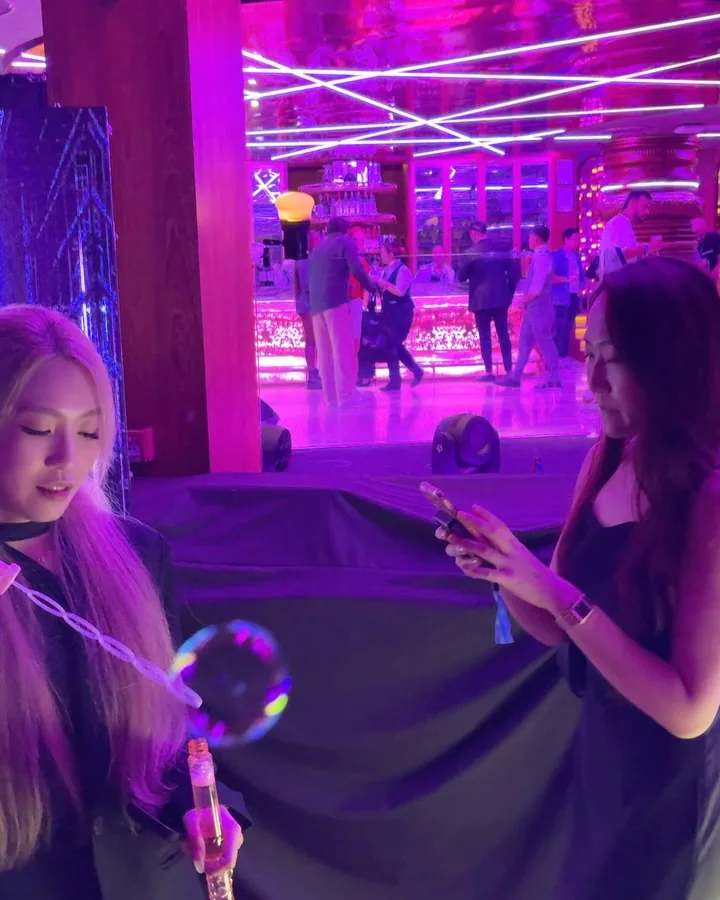 Guests with bubble wands under pink light